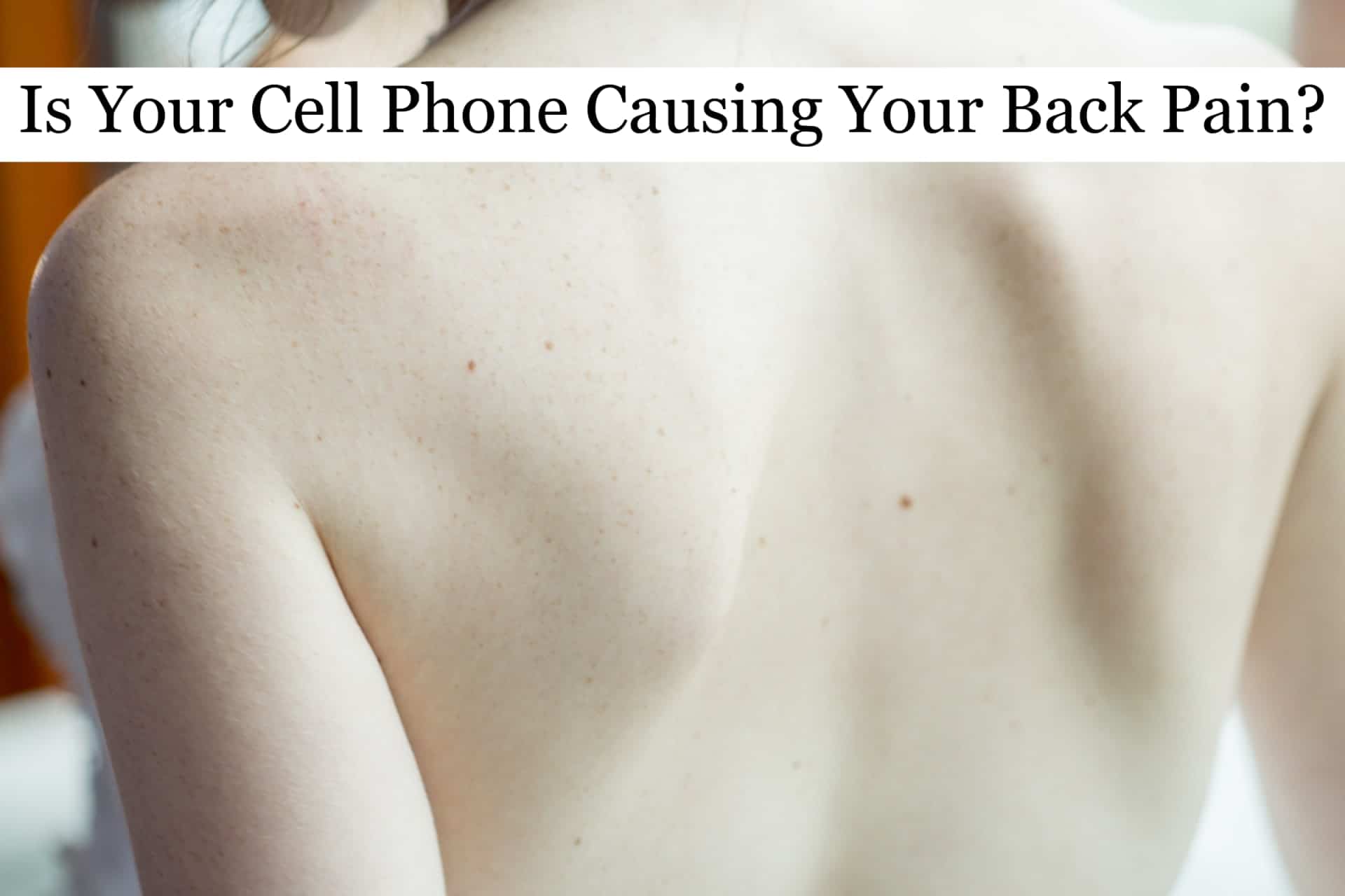 The bare back of a young woman suffering from back pain.